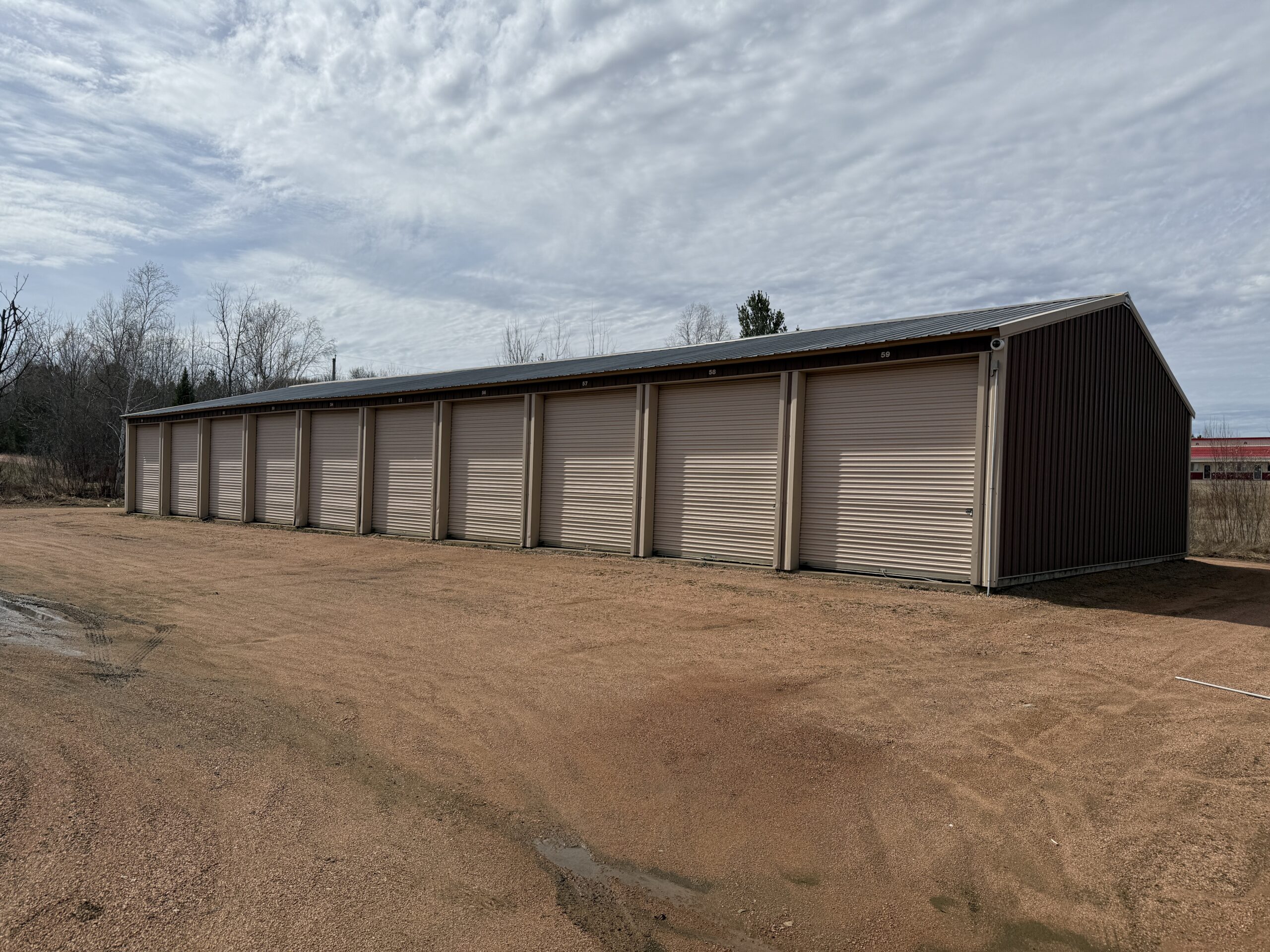 Row of numbered drive-up storage units with roll-up doors